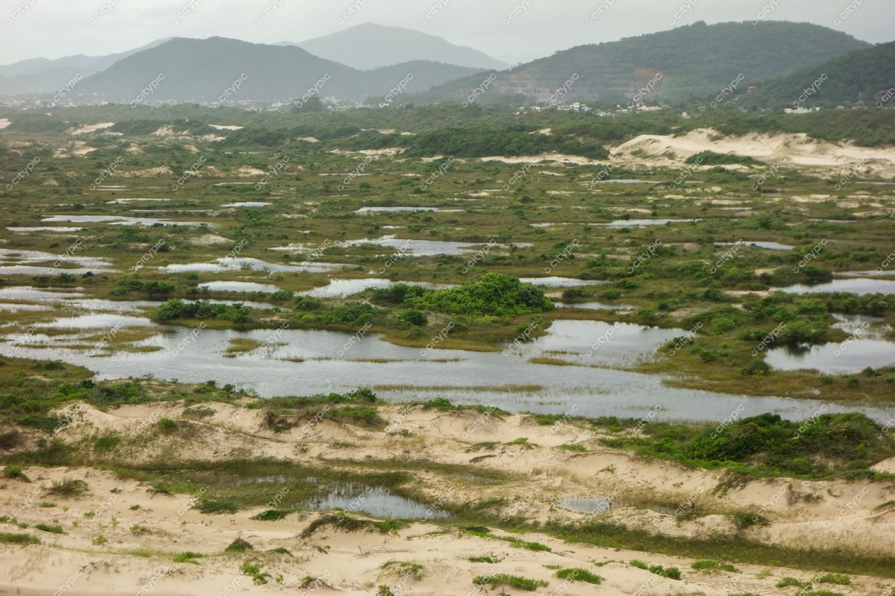 Florianópolis, Santa Catarina, charcos e vegetação com lagoas cercadas por gramados e montanhas sob céu nublado
