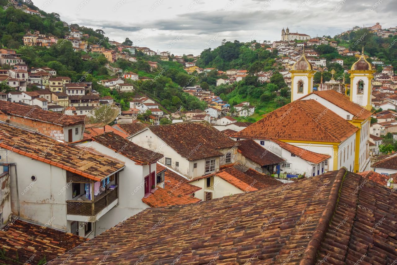 Ouro Preto, Minas Gerais, vista panorâmica com telhados de cerâmica e arquitetura colonial sob céu nublado e colinas verdes