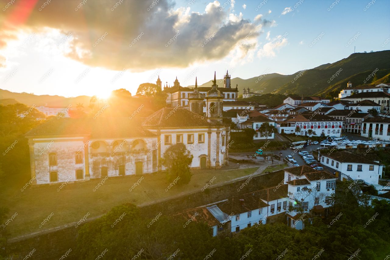 Ouro Preto, Minas Gerais ao pôr do sol com luz dourada destacando a arquitetura colonial e relevo montanhoso