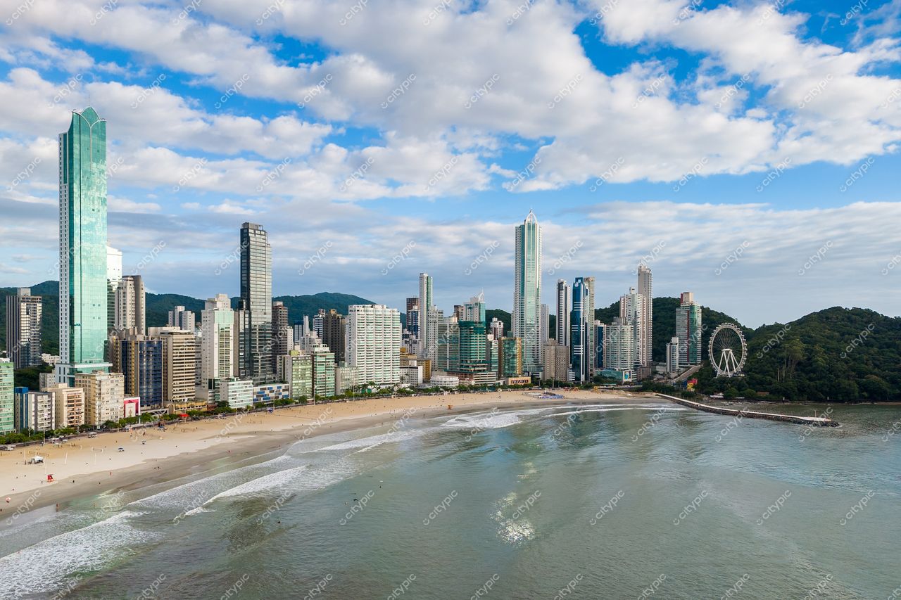 Balneário Camboriú, Santa Catarina, vista panorâmica com arranha-céus modernos e vegetação montanhosa ao fundo em dia nublado