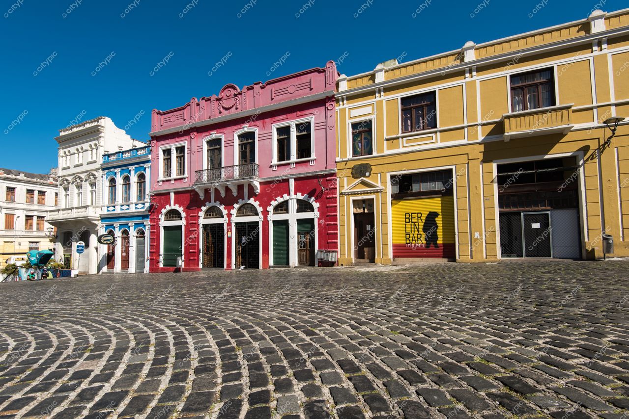 Curitiba, Paraná, rua tranquila com arquitetura colonial colorida e céu azul em dia ensolarado sem tráfego