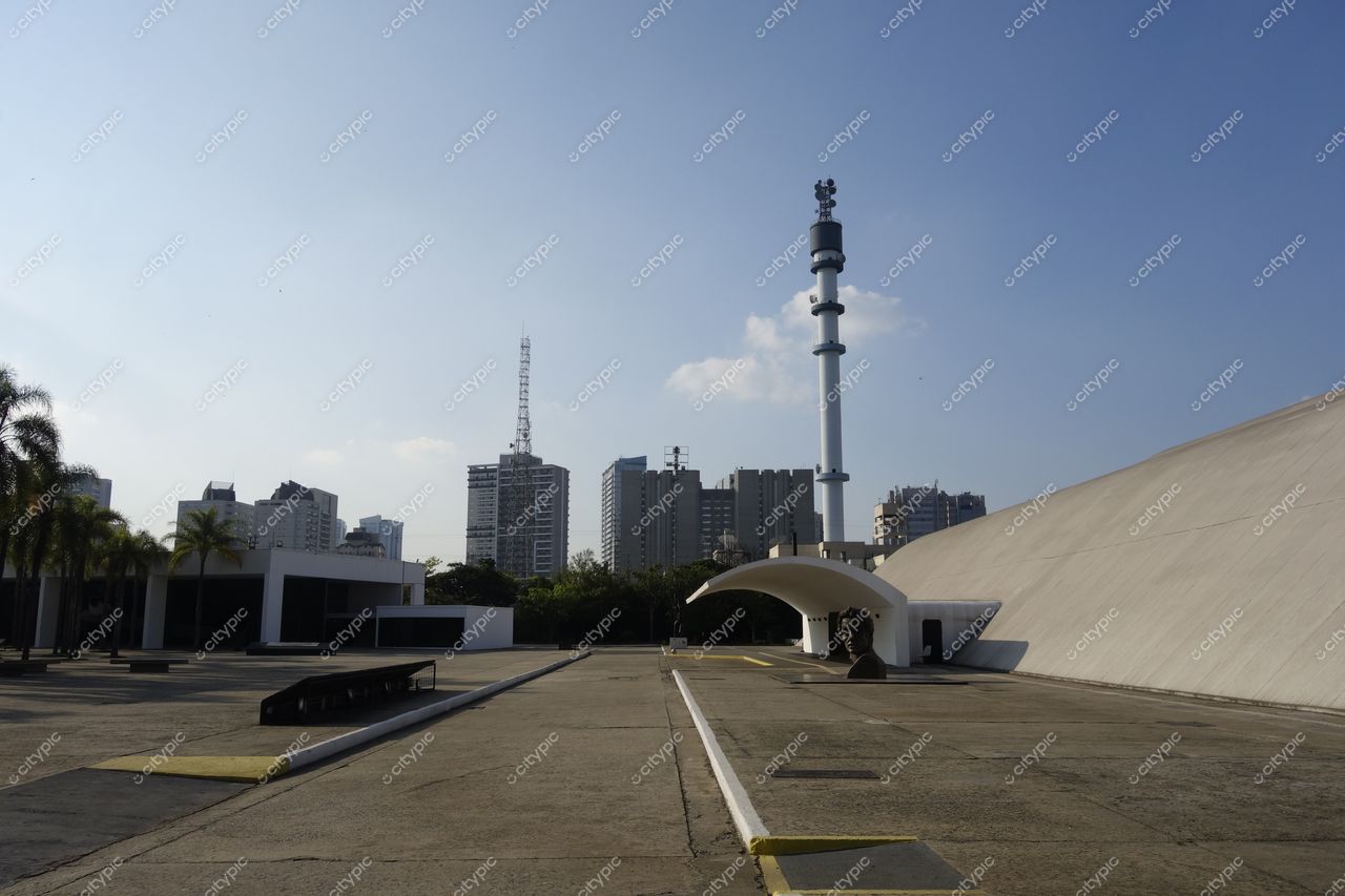 Parque Ibirapuera em São Paulo com arquitetura moderna, céu azul e vegetação contrastando com o horizonte urbano