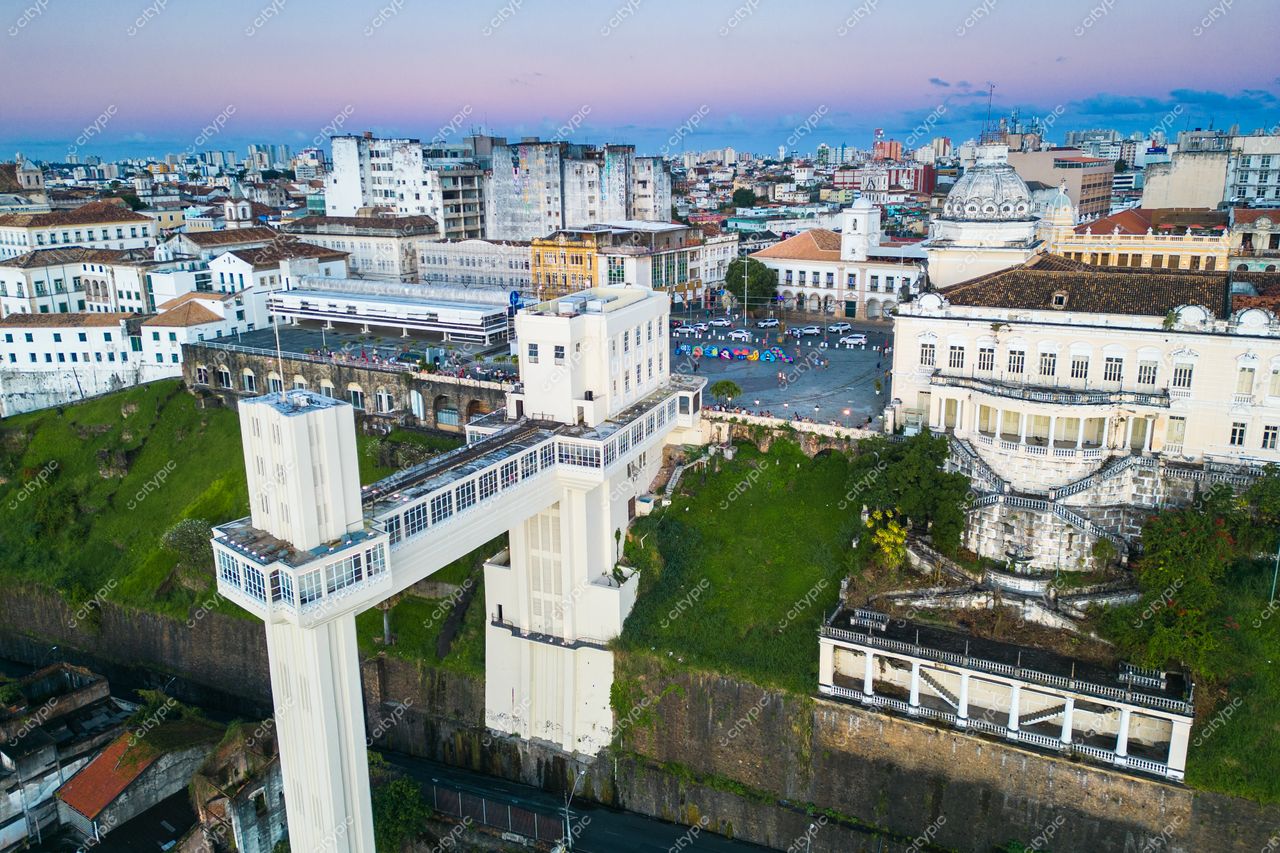 Salvador, Bahia vista aérea do Elevador Lacerda ao amanhecer com prédios variados e áreas verdes ao fundo