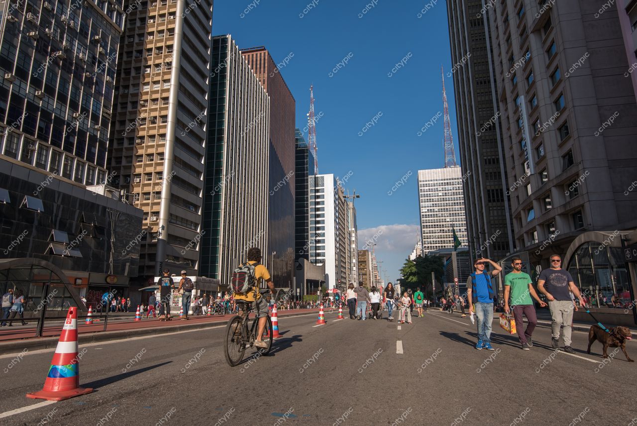 São Paulo, São Paulo, vista da Avenida Paulista em dia ensolarado com pessoas, ciclistas e cones de trânsito coloridos