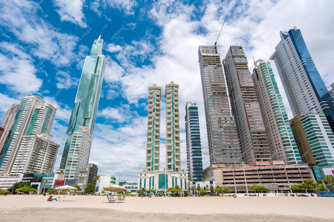 Balneário Camboriú, Santa Catarina, skyline com arranha-céus modernos sob céu parcialmente nublado e praia em primeiro plano
