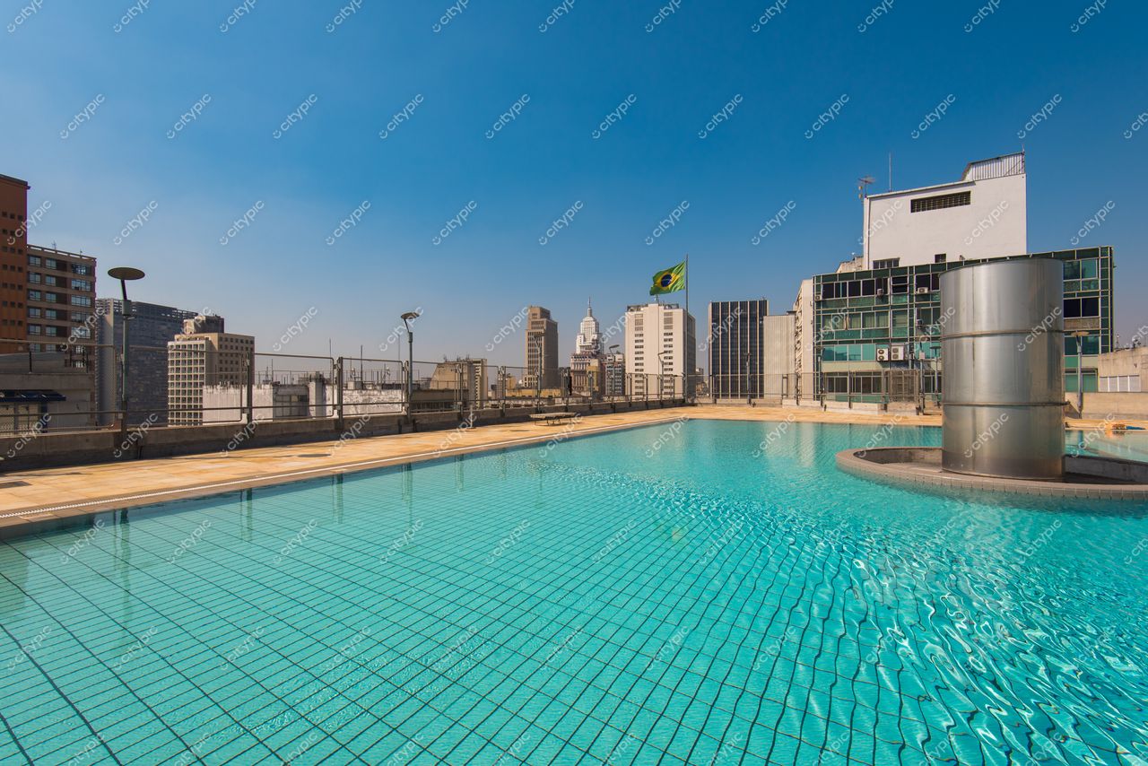 São Paulo, São Paulo, piscina em terraço com vista para edifícios modernos e bandeira do Brasil ao fundo