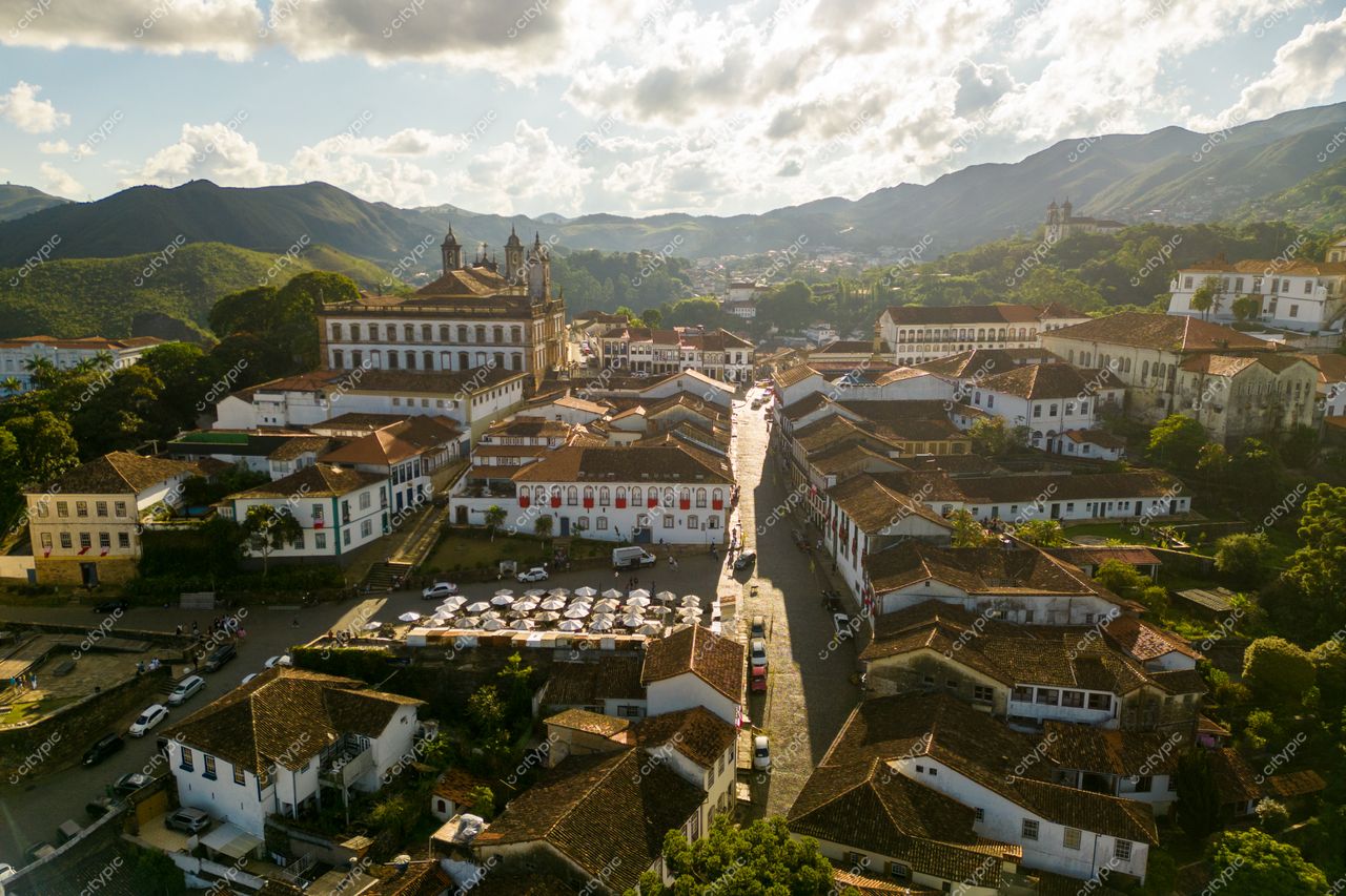 Ouro Preto, Minas Gerais em vista panorâmica com arquitetura colonial e montanhas verdes sob céu nublado ao entardecer