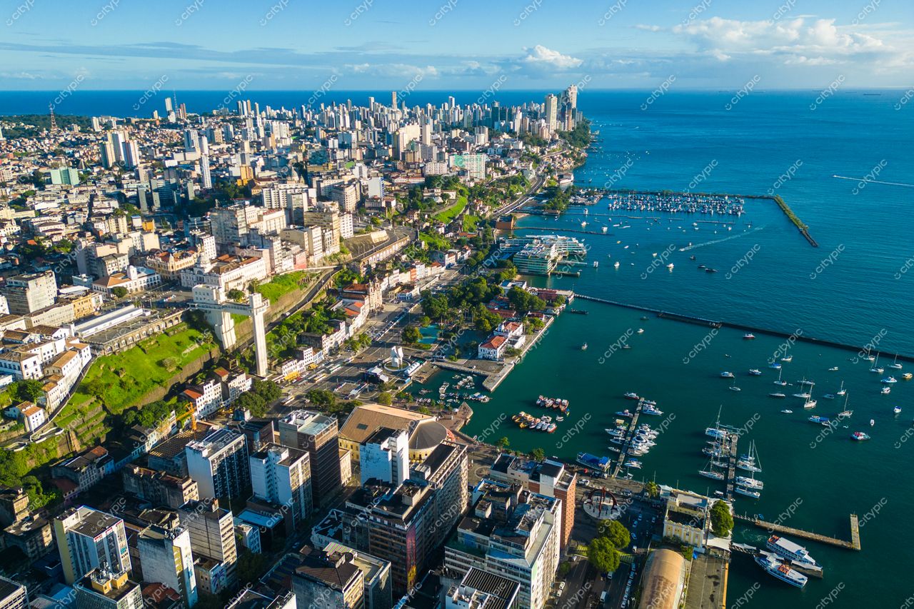 Salvador, Bahia vista panorâmica da orla com mar azul e embarcações ao entardecer entre prédios e áreas verdes