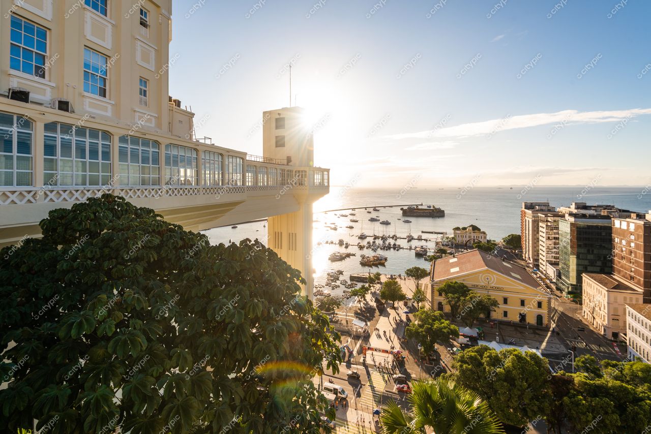 Salvador, Bahia ao amanhecer com o Elevador Lacerda e ruas movimentadas refletindo a luz suave do sol nascente