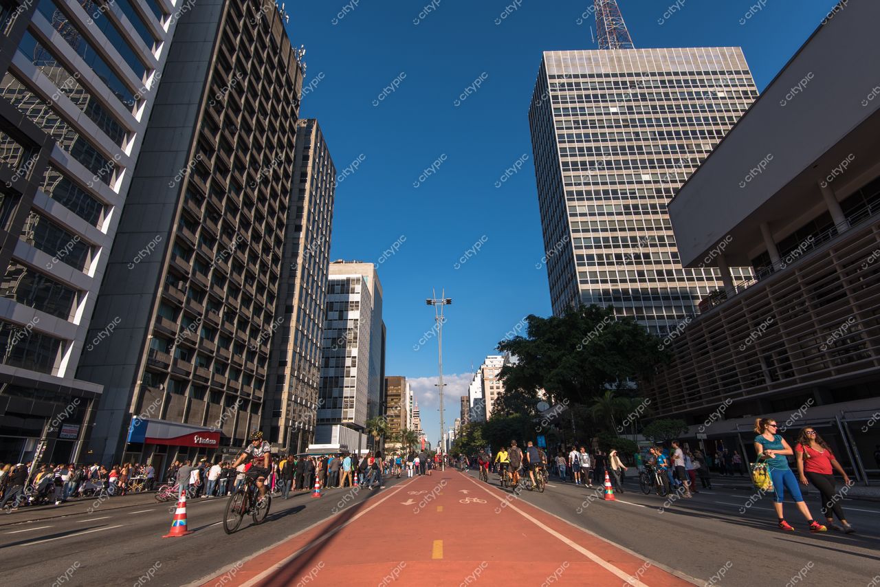 São Paulo, São Paulo, rua movimentada com ciclistas e edifícios modernos sob céu azul em dia claro