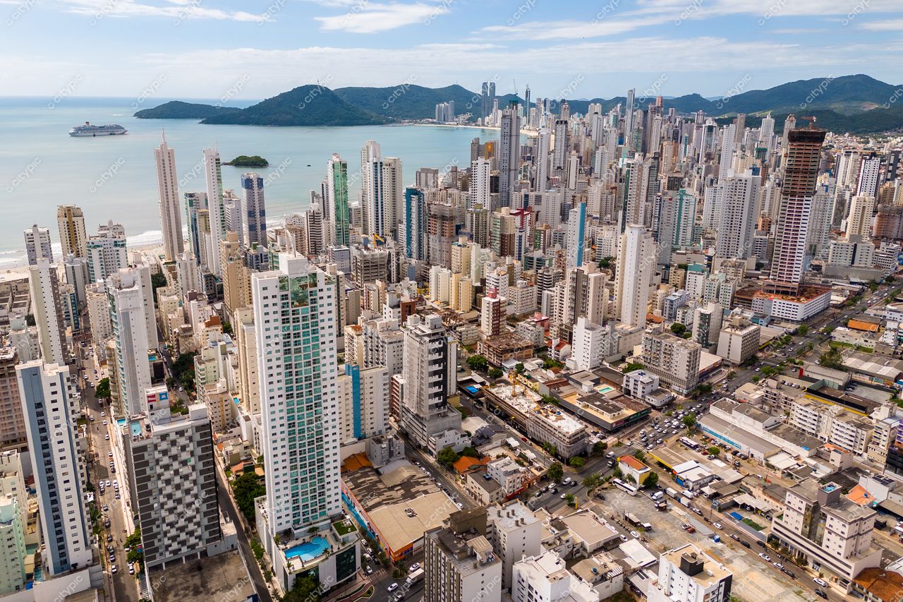 Balneário Camboriú, Santa Catarina, vista panorâmica com arranha-céus modernos e colinas sob céu parcialmente nublado