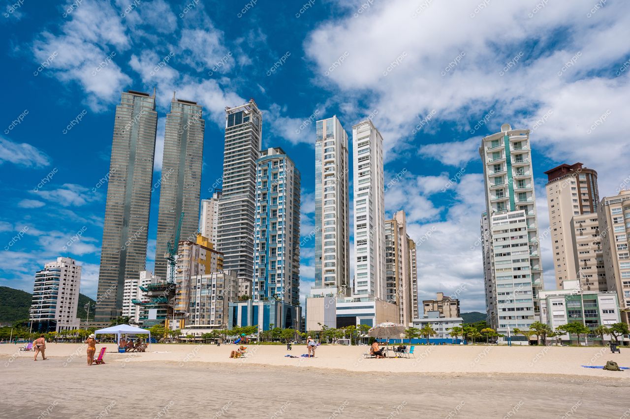 Balneário Camboriú, Santa Catarina, orla com arranha-céus modernos e vegetação em dia ensolarado e céu parcialmente nublado