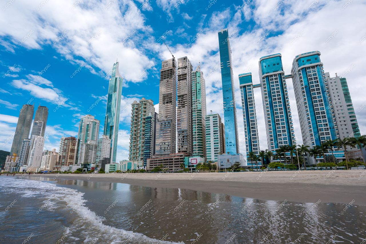 Balneário Camboriú, Santa Catarina, vista da orla com arranha-céus modernos e céu parcialmente nublado ao fundo