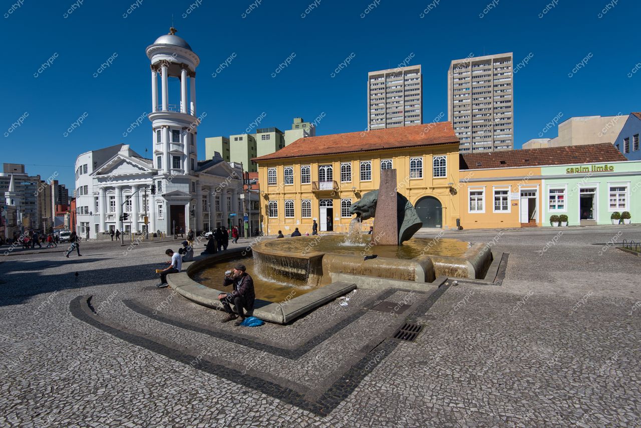 Curitiba, Paraná, Praça 29 de Março com fonte central e edifícios históricos em dia ensolarado e céu azul