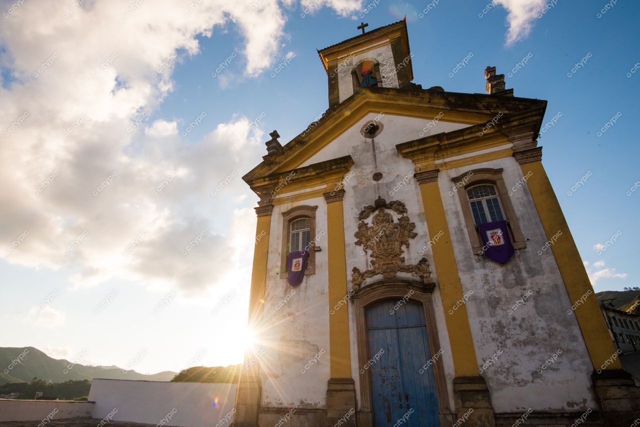 Ouro Preto, Minas Gerais, fachada da Igreja de São Francisco de Assis iluminada pelo pôr do sol com vegetação ao redor