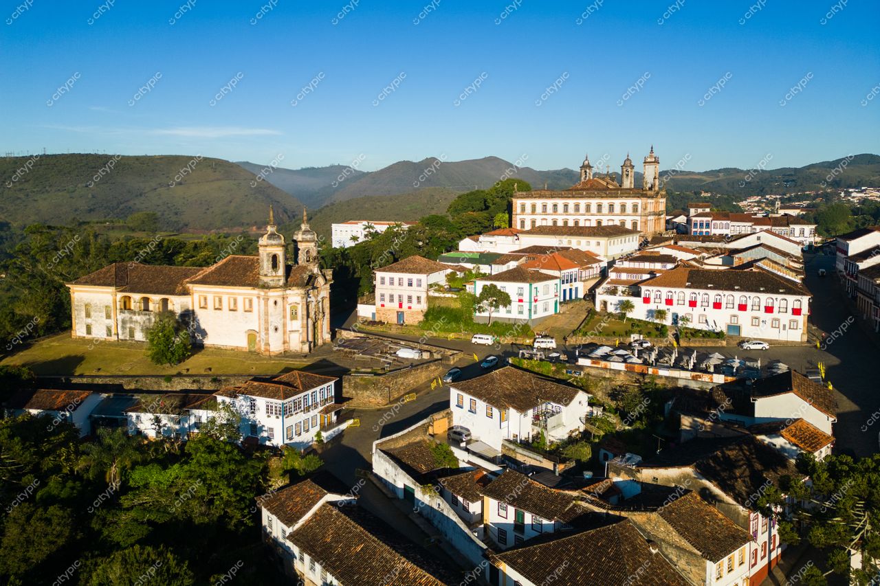 Ouro Preto, Minas Gerais vista panorâmica ao amanhecer com igrejas coloniais e vegetação em encosta montanhosa tranquila