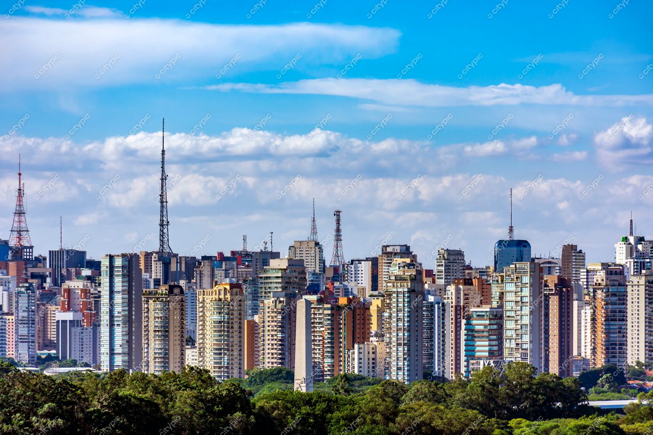 São Paulo, São Paulo, skyline com edifícios variados e torres de transmissão sob céu azul claro e nuvens brancas