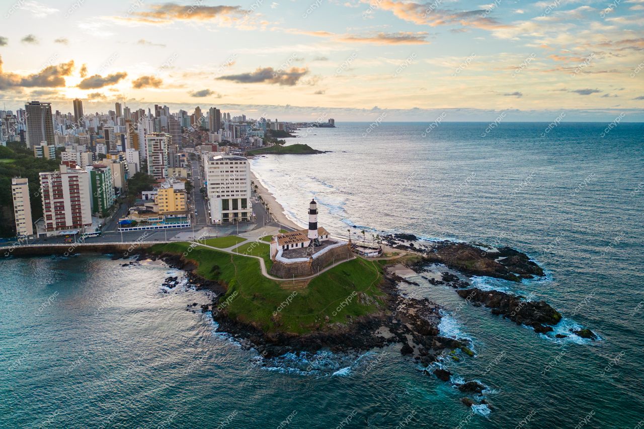 Salvador, Bahia vista aérea do Farol da Barra ao entardecer com prédios urbanos e vegetação costeira