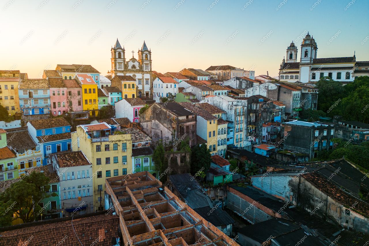 Salvador, Bahia vista aérea ao amanhecer com luz suave destacando construções coloridas e igrejas históricas entre áreas verdes