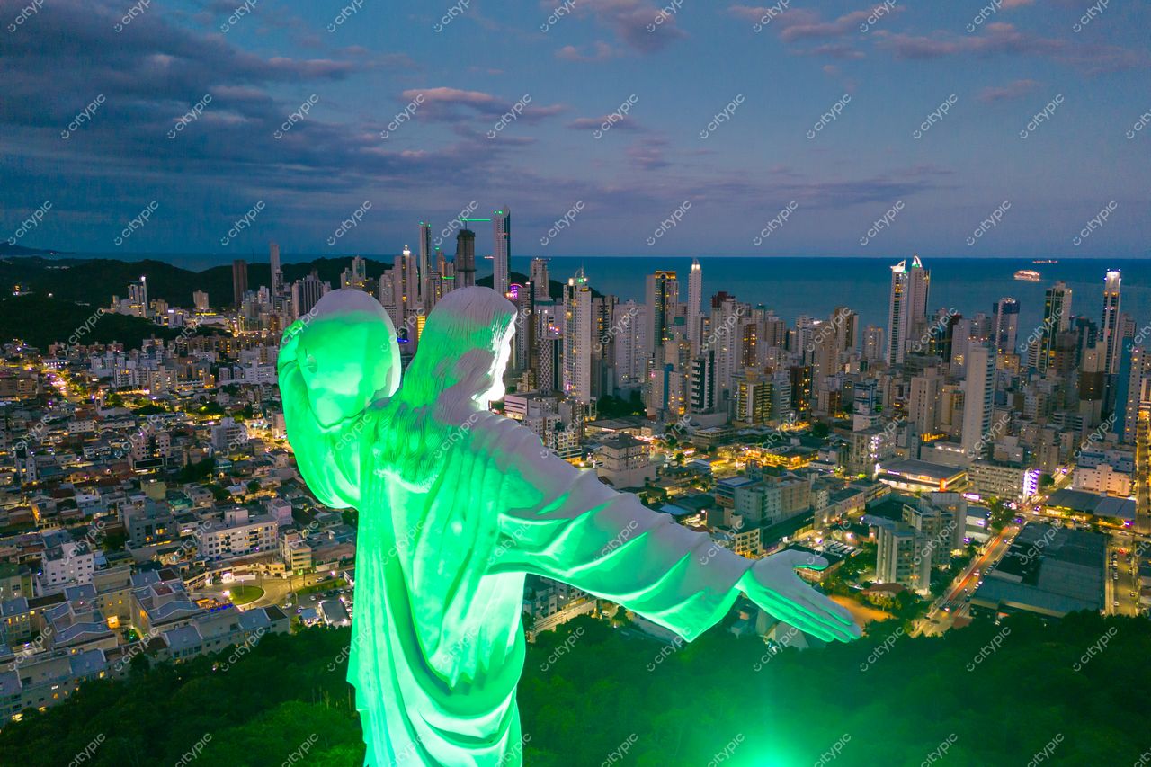 Balneário Camboriú, Santa Catarina, vista panorâmica ao entardecer com Cristo Luz iluminado e arranha-céus modernos