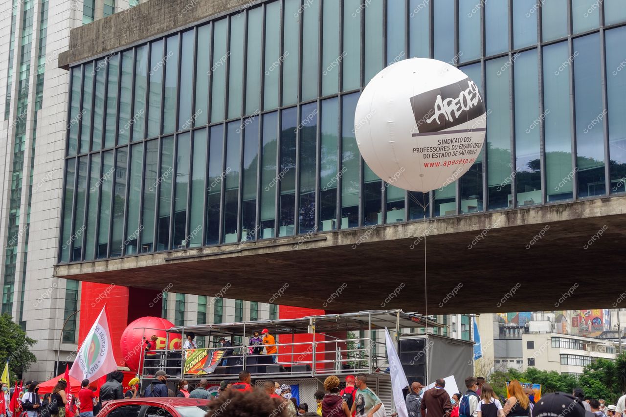 MASP – Museu de Arte de São Paulo com multidão em protesto e balão branco sob luz do dia e vegetação próxima