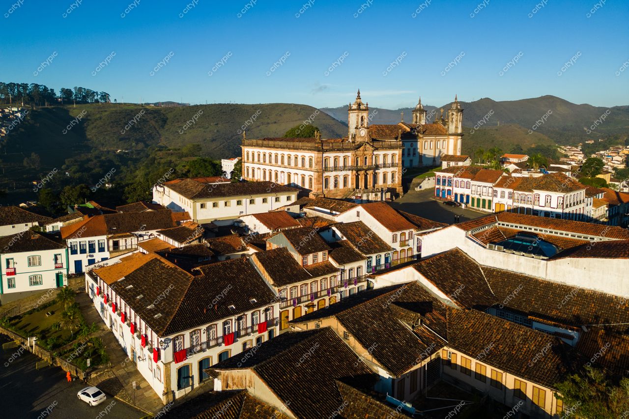 Ouro Preto, Minas Gerais em dia ensolarado com arquitetura colonial e montanhas ao fundo sob iluminação suave da manhã