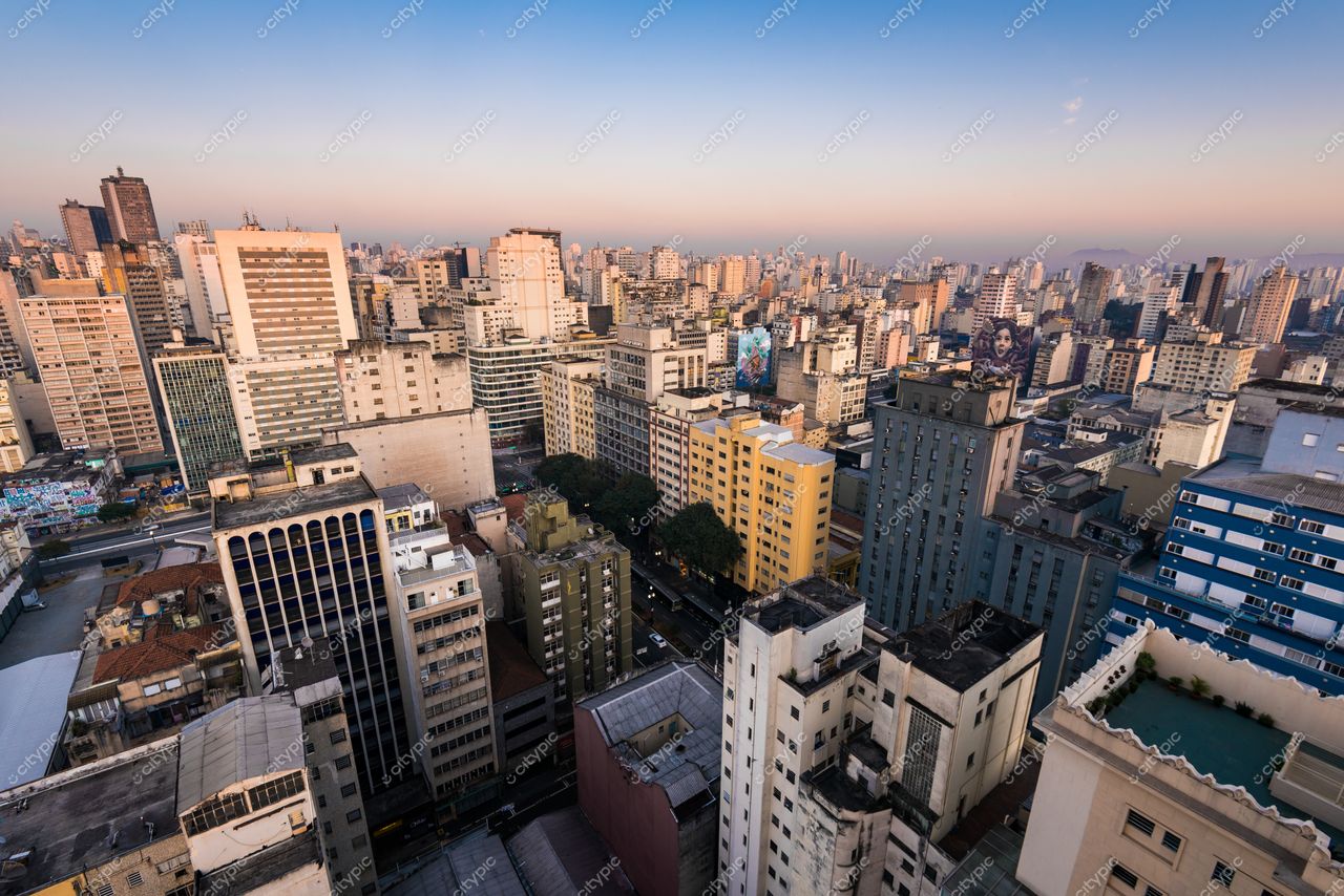 São Paulo, São Paulo, vista panorâmica ao pôr do sol com arranha-céus, vegetação esparsa e tráfego ativo
