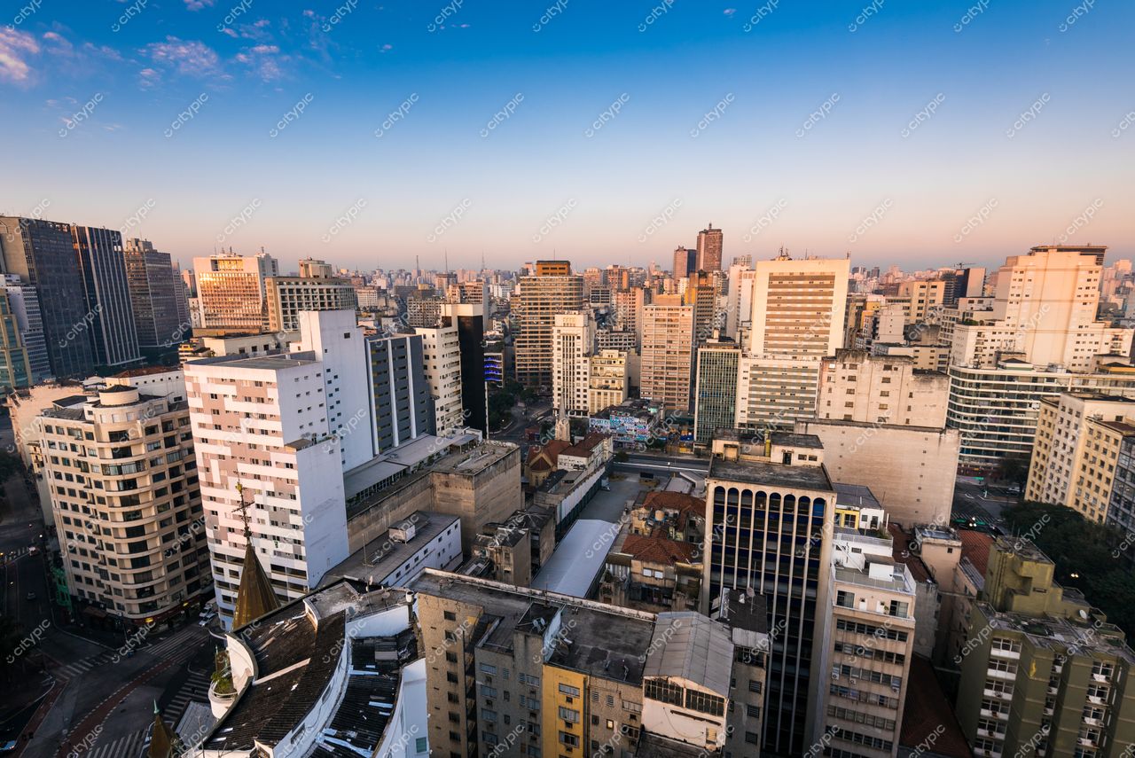São Paulo, São Paulo, vista panorâmica da cidade ao amanhecer com edifícios altos e vegetação esparsa entre eles