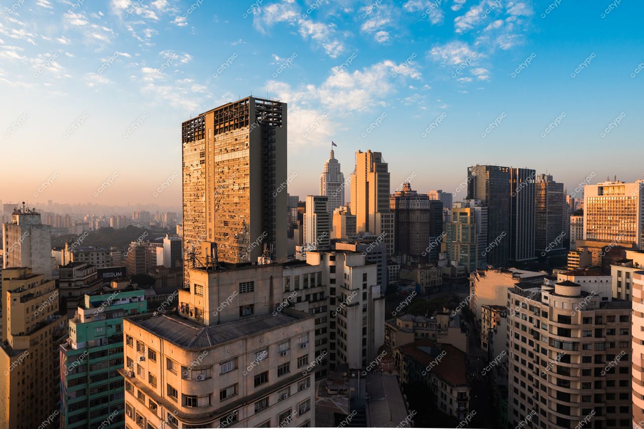São Paulo, São Paulo, vista panorâmica ao amanhecer com arranha-céus iluminados e céu claro sem vegetação