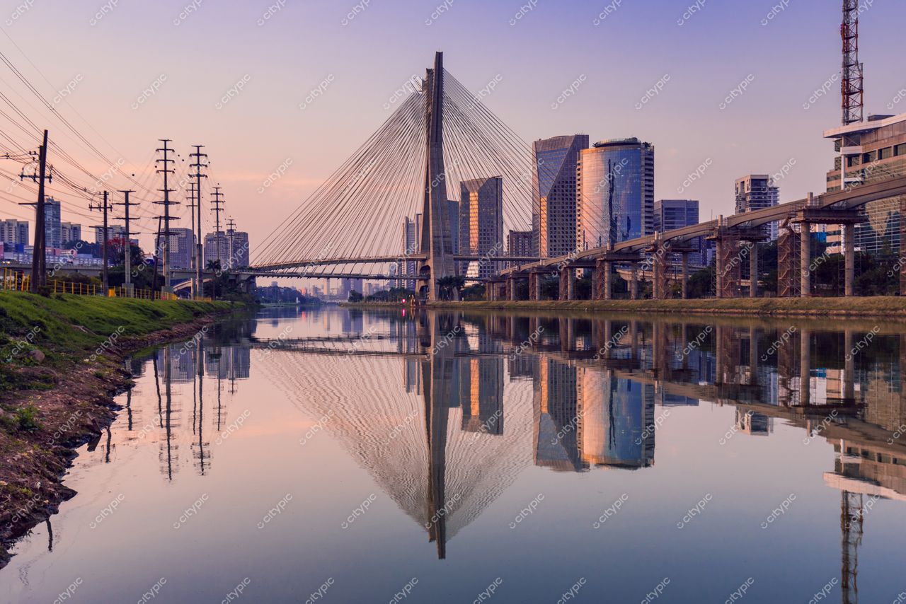 São Paulo, São Paulo, vista da ponte estaiada ao entardecer com reflexos no rio e céu azul e laranja