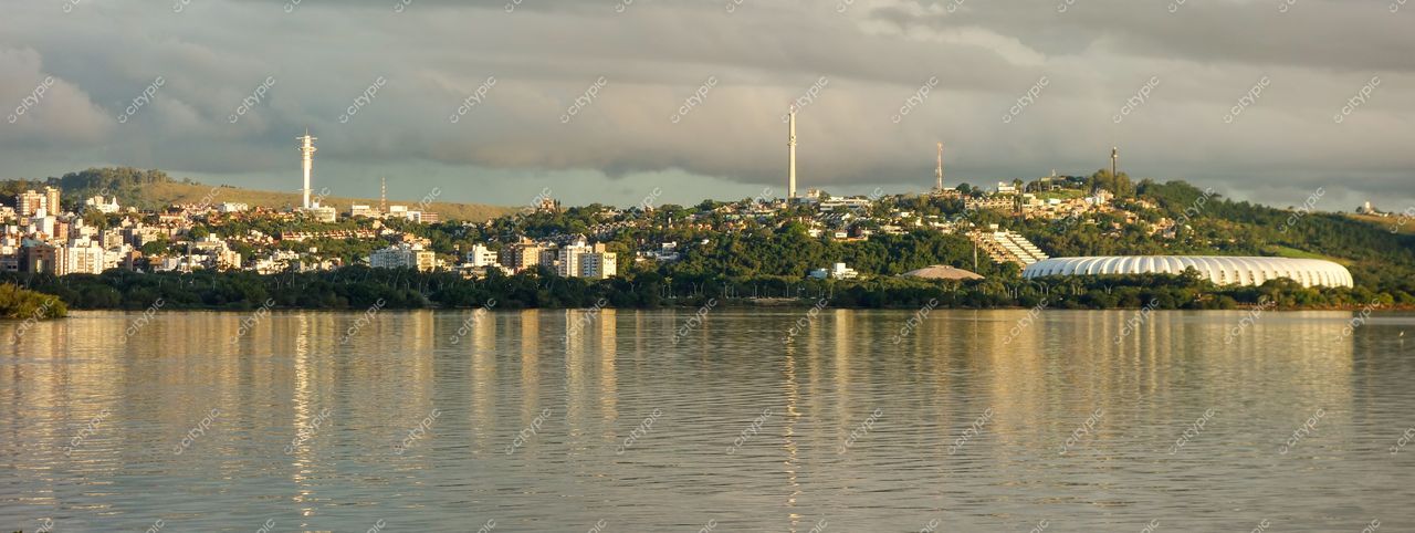 Porto Alegre, Rio Grande do Sul, vista panorâmica ao amanhecer com lago refletindo arquitetura moderna e colinas verdes