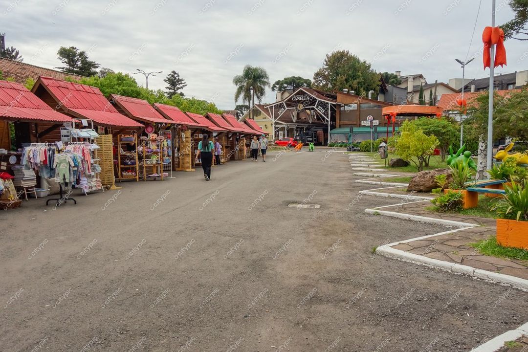 Canela, Rio Grande do Sul, rua tranquila com barracas de artesanato e edifício rústico em dia nublado
