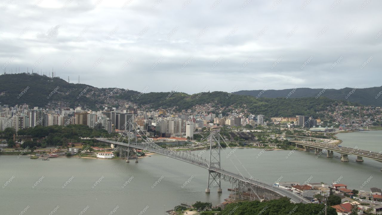 Centro, em Florianópolis com vista panorâmica da interseção urbana e natureza, ponte sobre água calma e céu nublado