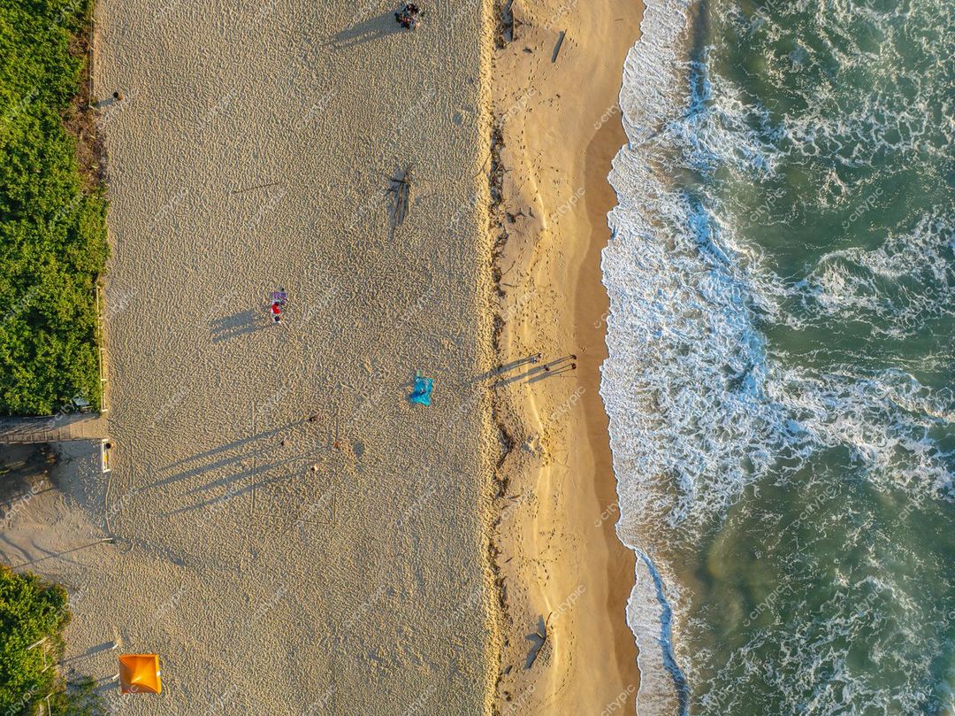 Itajaí, Santa Catarina vista aérea da praia com areia clara e águas esverdeadas ao entardecer com pessoas na areia