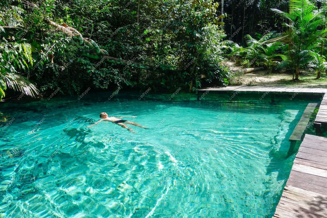 Presidente Figueiredo, Amazonas, pessoa nadando em piscina cristalina cercada por vegetação tropical e relevo suave