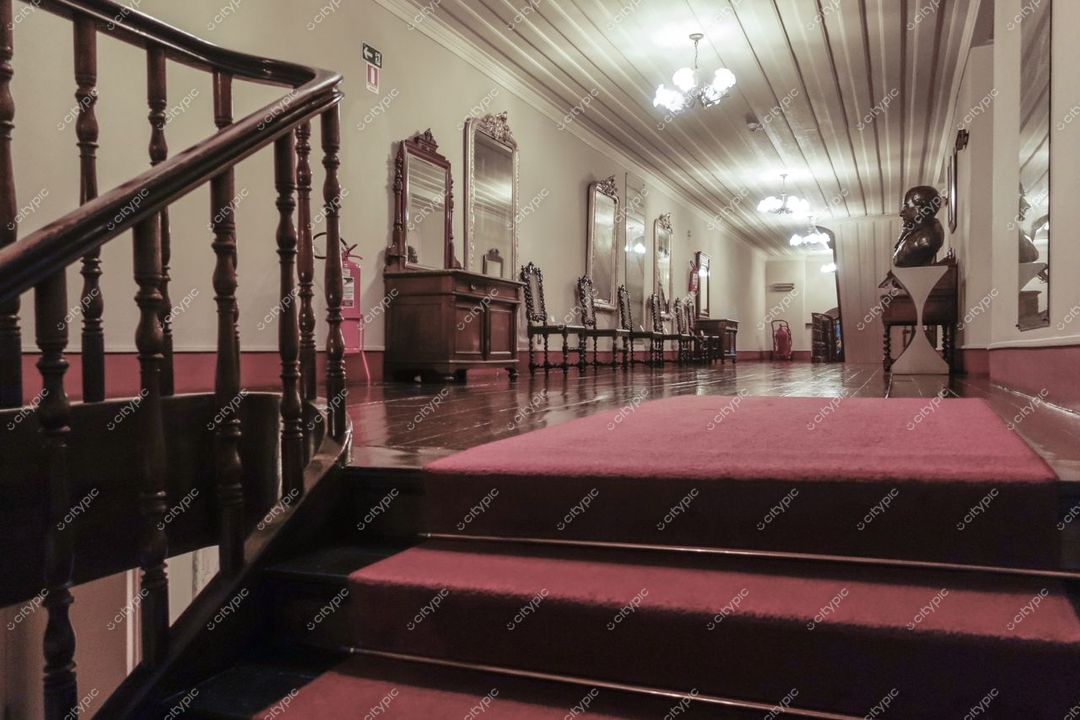 Manaus, Amazonas, corredor de edifício clássico com piso de madeira escura e iluminação suave em ambiente acolhedor