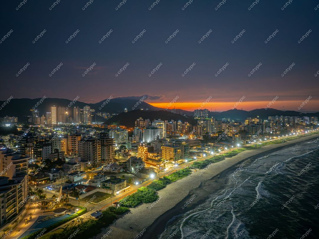 Itajaí, Santa Catarina vista noturna com orla iluminada e céu em transição de cores durante o pôr do sol
