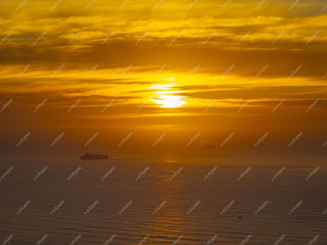 Itajaí, Santa Catarina, pôr do sol sobre o Oceano Atlântico com silhuetas de navios e reflexos na água