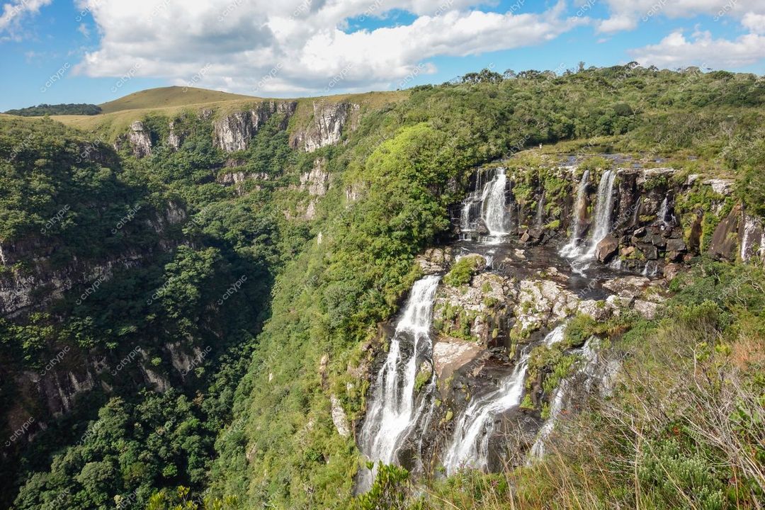 Cambará do Sul, Rio Grande do Sul, cascatas em relevo montanhoso com vegetação densa e céu parcialmente nublado