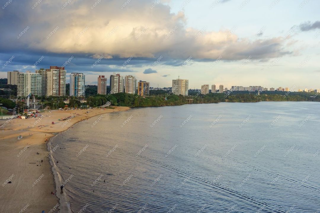 Manaus, Amazonas, vista da orla ao entardecer com prédios altos, riacho calmo e vegetação nas proximidades