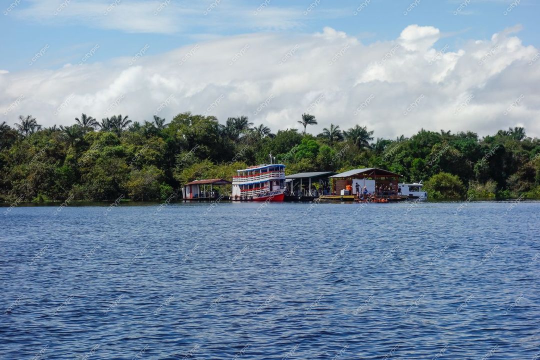 Manaus, Amazonas, barco de passageiros ancorado em margem com construções rústicas e vegetação exuberante ao fundo