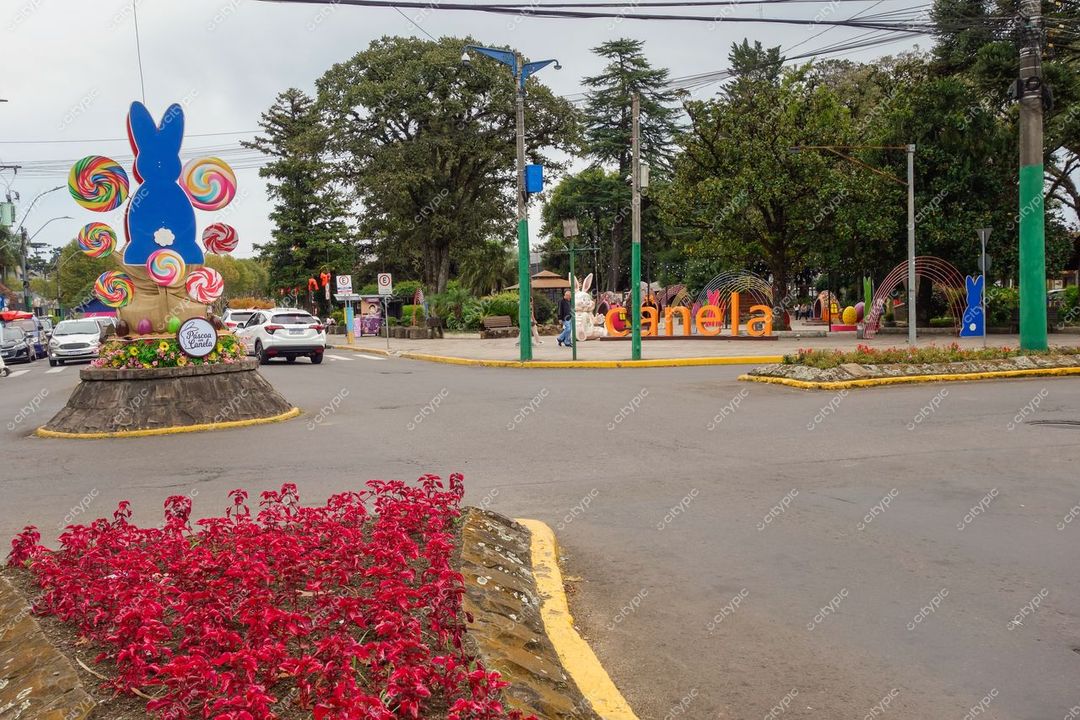 Canela, Rio Grande do Sul, rotatória decorada com coelhos e flores vermelhas em dia nublado e tráfego moderado