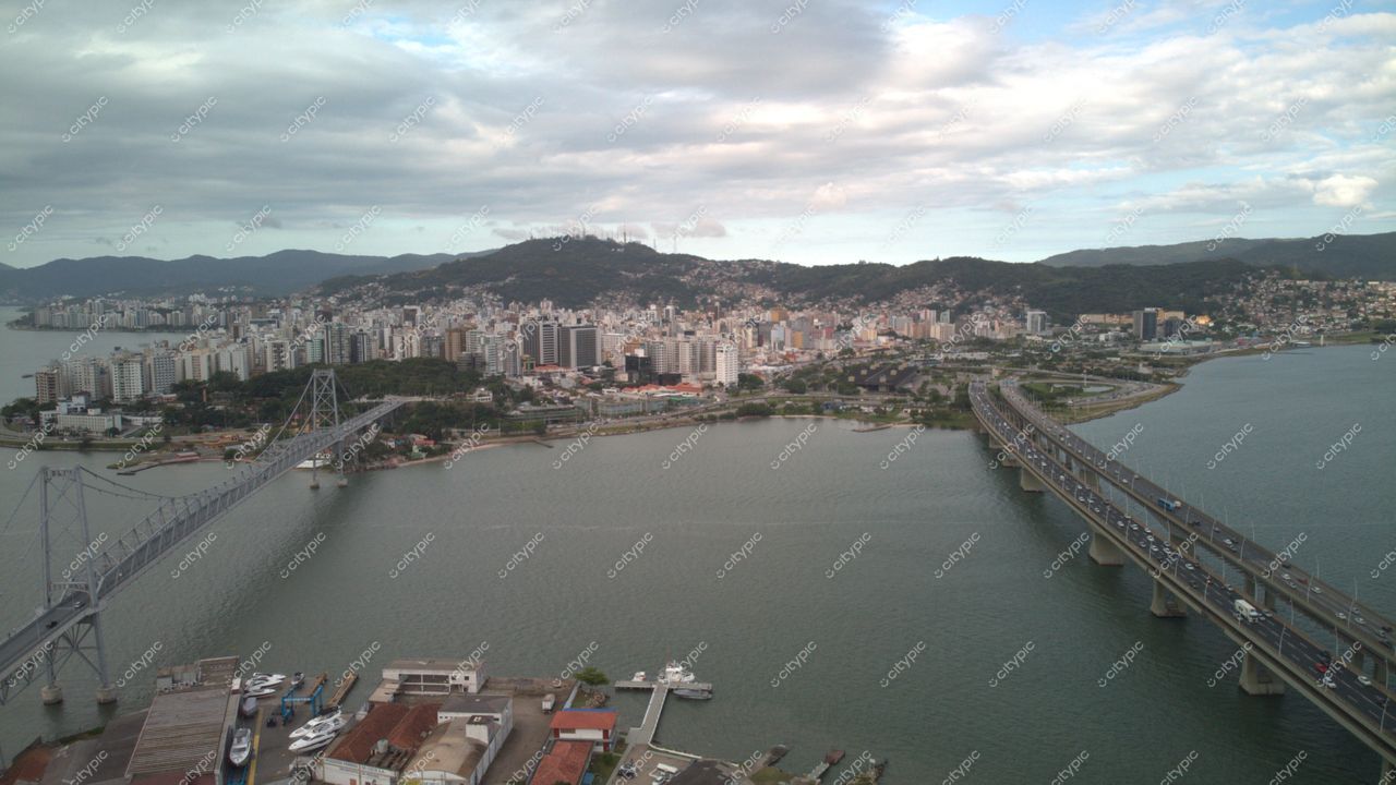 Centro de Florianópolis com vista panorâmica do lago, ponte à esquerda e vegetação nas encostas ao fundo