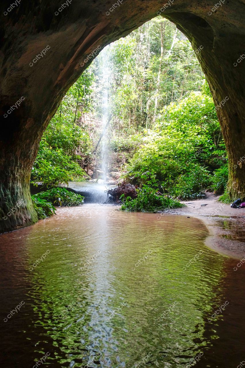 Presidente Figueiredo, Amazonas, abertura em rocha com cachoeira iluminada e vegetação densa ao redor