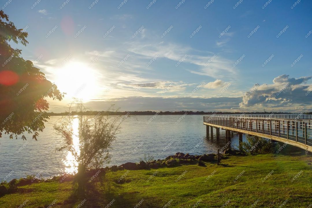 Porto Alegre, Rio Grande do Sul, crepúsculo sereno com lago refletindo luz dourada e vegetação abundante