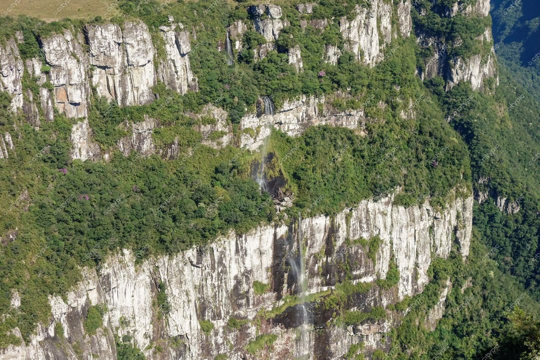 Cambará do Sul, Rio Grande do Sul vista panorâmica de paredão rochoso com vegetação e queda d’água durante o dia