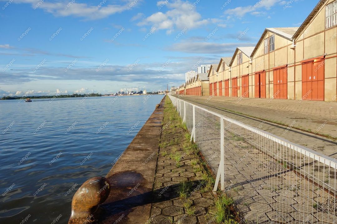 Porto Alegre, Rio Grande do Sul vista do cais com armazéns industriais e água calma sob céu nublado
