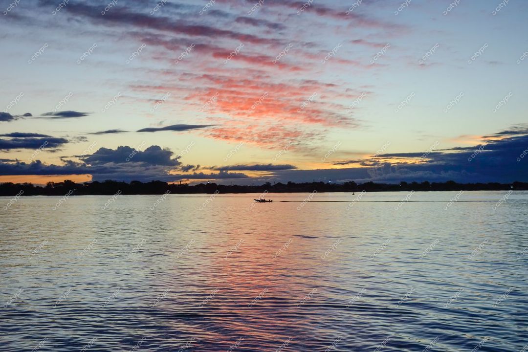 Porto Alegre, Rio Grande do Sul captura pôr do sol com nuvens rosa e azul refletidas na lagoa tranquila
