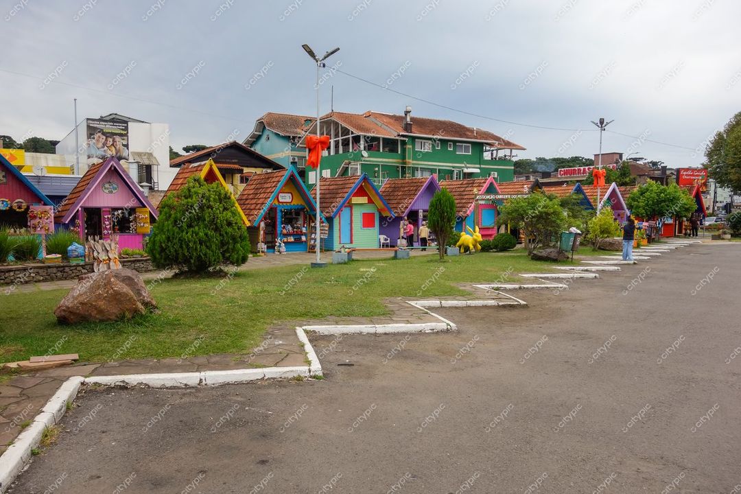 Canela, Rio Grande do Sul, casas coloridas em dia nublado com grama e árvores ao redor da rua pavimentada