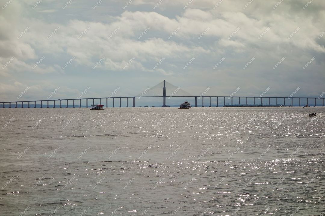 Manaus, Amazonas, vista do Rio Amazonas com ponte moderna ao fundo e reflexos do sol na água calma